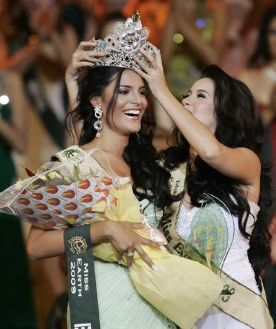 Miss Earth 2008 Karla Paula Henry (R) transfers her crown to Miss Brazil Larissa Ramos, 20, a biology student, after Ramos won the Miss Earth 2009, at an eco-village in Boracay resort in Aklan province, central Philippines, November 22, 2009.[Agencies]
