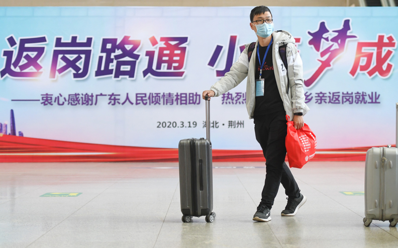 一名湖北荆州的务工人员进入候车室，准备搭乘专列至广东返岗就业（3月19日摄）。新华社记者 程敏 摄