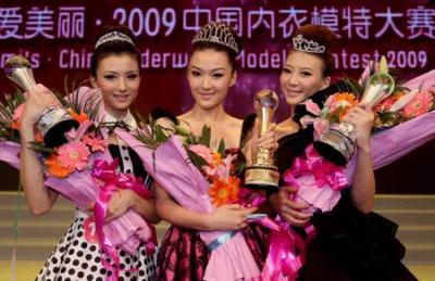 The first prize winner Mao Huan(C) is flanked by runner-up Wang Mingshun and third prize winner Xu Tingting as they pose for a photo after the final of China Underwear Contest 2009 in Nanning, capital of southwest China's Guangxi Zhuang Autonomous Region, on Dec. 6, 2009. (Xinhua/Chen Jianli)