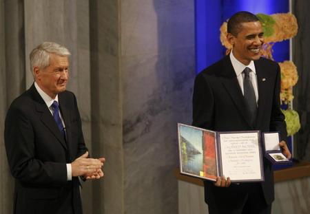 Norwegian Nobel Committee chairman Thorbjoern Jagland (L) applauds as Nobel Peace Prize laureate US President Barack Obama poses with his diploma and medal after receiving the prize at the award ceremony in Oslo City Hall December 10, 2009.[Agencies]
