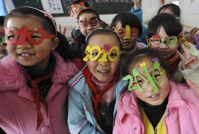 Students pose for a photo wearing spectacle frames shaped in the number "2010" to welcome the upcoming New Year at a primary school in Hefei, Anhui province December 30, 2009.[Photo/Agencies]