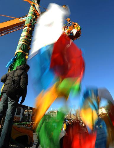 Workers replace prayer streamers around the Jokhang Temple in Lhasa, capital of southwest China's Tibet Autonomous Region, Jan. 26, 2010. Lots of Buddhist believers write down their New Year wishes on prayer streamers and tie them up to the five Buddhist scripture poles of the temple during a traditional ceremony to celebrate the New Year of the traditional Tibetan calendar, which falls on Feb. 14 this year.(Xinhua/Chogo)