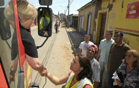 Chile's President Michelle Bachelet (L) shakes hands with a resident at an earthquake-destroyed area in Concepcion, some 100 km (62 miles) south of the epicenter February 27, 2010. (Xinhua/Reuters Photo)