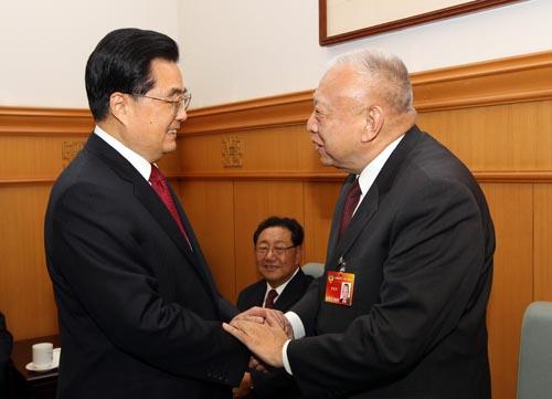 Chinese President Hu Jintao (L), who is also General Secretary of the Central Committee of the Communist Party of China, talks with Tung Chee-hwa, vice chairman of the National Committee of the Chinese People's Political Consultative Conference (CPPCC), before the opening meeting of the Third Session of the 11th CPPCC National Committee at the Great Hall of the People in Beijing, capital of China, March 3, 2010.(Xinhua/Lan Hongguang)