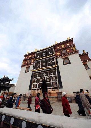 Picture taken on March 14, 2010, shows tourists visiting the Gedan Songzanlin Lamasery, known as a "mini-Potala Palace," in Shangri-La County, southwest China's Yunnan Province. Built in 1679 in the Qing Dynasty and covering an area of 330,000 sq m, the Songzanlin Lamasery is the largest of its kind for Tibetan Buddhism in Yunnan. It is one of Yunnan's most famous destinations for pilgrims and a popular tourist attraction. [Xinhua Photo]