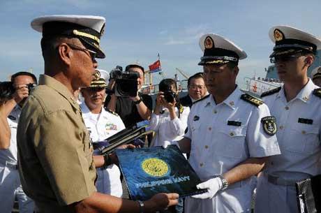 Qiu Yanpeng (2nd R), commander of the Chinese Navy Task Force 525 military escort team, and Felicimo Lozuraga (L), and Felicimo Lozuraga, deputy head of the Operational Headquarters of the Philippine Naval Force, exchange gifts during a farewell ceremony in Manila, capital of the Philippines, April 17, 2010. (Xinhua/Tan Weibing)
