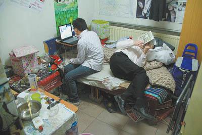 Xu (left), who works in a bank, and his workmate are crammed in a less than ten-square-meter room that costs 450 yuan per month.