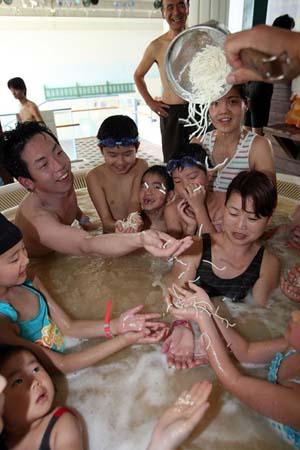Visitors enjoy the imitation noodles bath agent being thrown into "soup noodle spa" at the Hakone Yunessun Spa on April 19, 2008 in Hakone, Kanagawa Prefecture, Japan. The spa, which has previously offered customers spa baths filled with chocolate and Beaujolais wine, is celebrating their 10 millionth visitor since their opening in 2001 with the Soup Noodle Spa until June 30. (April 19, 2008 - Photo by Junko Kimura/Getty Images AsiaPac) 