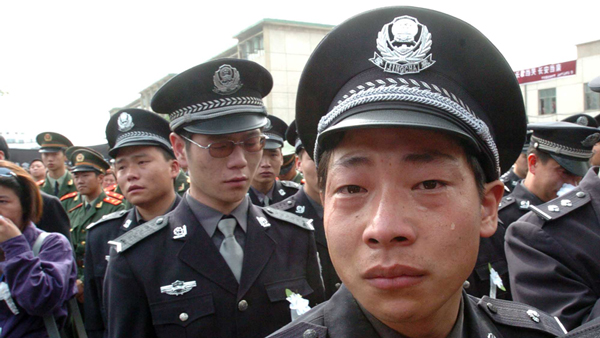 2004年4月17日上午，河南省登封市万人空巷送别任长霞。一张泪水涟涟的脸，身后是悲戚的警察和群众。送别任长霞的图片中，这张照片感动了不少人。