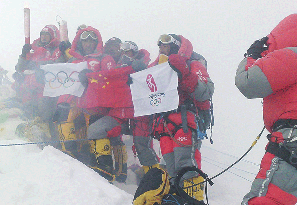 2008年奥运圣火首次登顶珠峰，火炬手欢庆胜利，展示中国国旗、奥运五环旗（阿旺罗布摄）