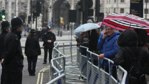 数以千计人群17日一早就撒切尔夫人灵车队途经街道两旁雨中静候。