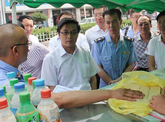 山西省晋中市纪委副书记高俊德（左二）和相关部门的工作人员对小摊贩进行检查（资料图片）。