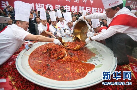 10月19日,厨师们将制作好的剁椒鱼头盛入盘中。