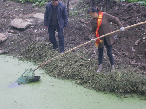 志愿者们清理河面漂浮物