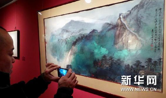  1月21日，观众在“张大千艺术展”上拍摄一幅张大千的绘画作品。新华网图片 李明放 摄