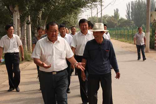 吴永虎带领村民查看蔬菜大棚和花卉基地