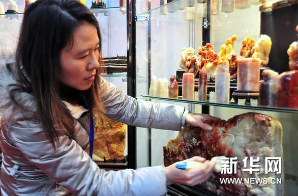     3月7日，来自福建的客商在擦拭寿山石雕件。新华网图片 邓华 摄