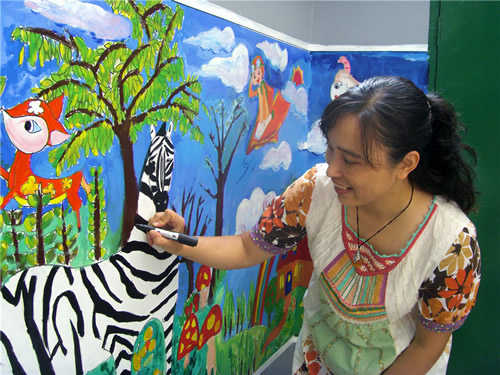 王小燕带领孩子们画缤纷多彩的校园壁画并亲自示范