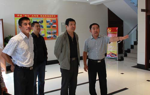 刘居文（右1）为上级检查组介绍工作