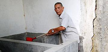 图为张启业老人在冲洗厕所。