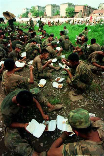 1998年抗洪抢险现场战士们正在吃午餐
