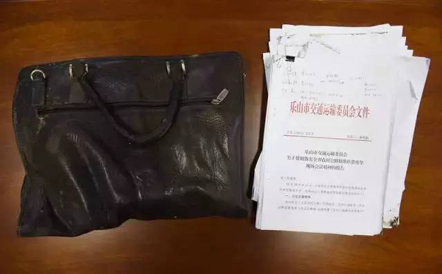 王川遇难时所携带公文包及包内所装文件，公文包上沾有血迹（2月13日摄）。新华社记者 刘坤 摄