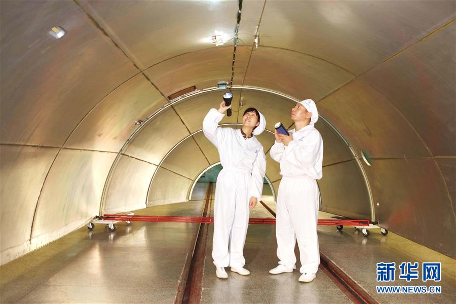 　　在西昌卫星发射中心总装车间，科研人员正在交接产品(2009年8月9日摄)。新华社发（航天科技集团第一研究院供图）