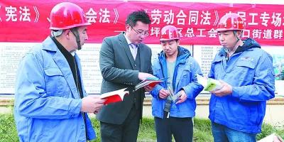 2018年11月23日，重庆市沙坪坝区总工会公益律师王奎（左二）向进城务工人员讲解法律知识。光明图片/视觉中国