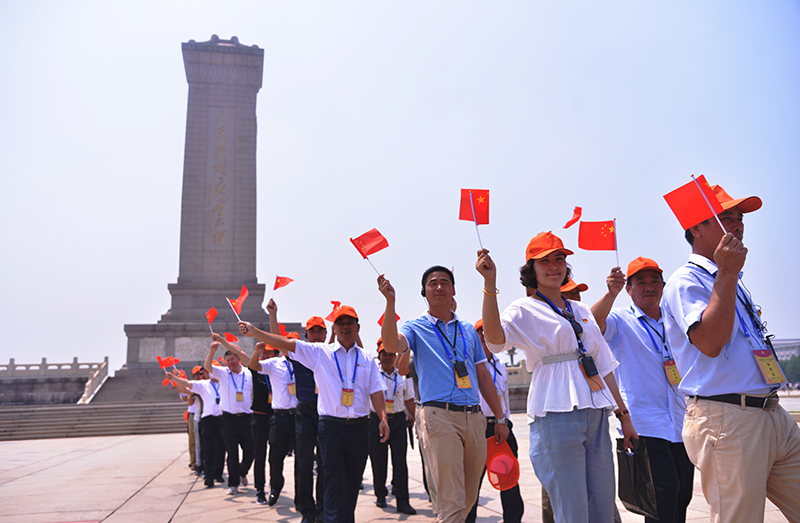 学员挥舞着红旗瞻仰人民英雄纪念碑