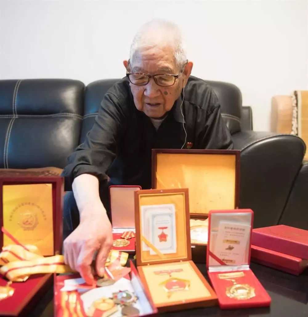 胡兆富在家中展示自己所获的军功章（7月15日摄）。新华社记者 翁忻旸 摄