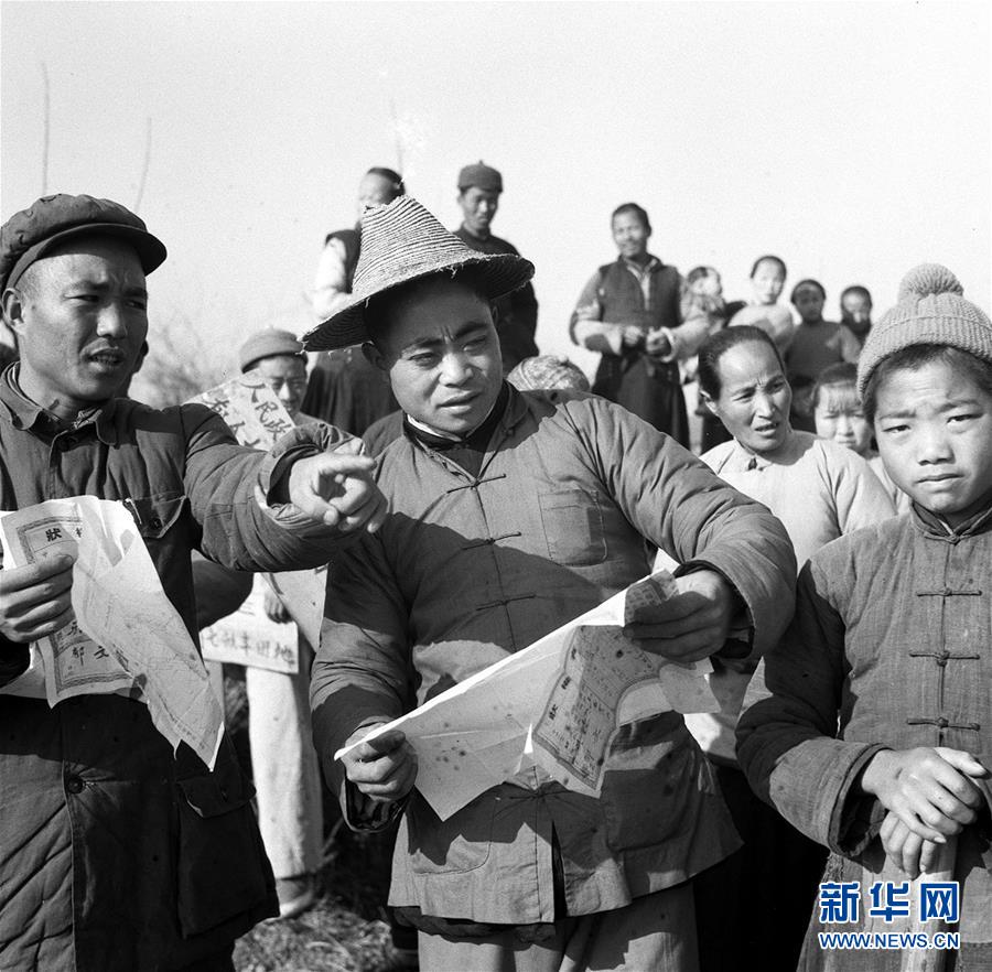 这是1950年浙江省杭县临平区，土改工作队的工作人员（左）带领农民进行分田。新华社发（资料照片）