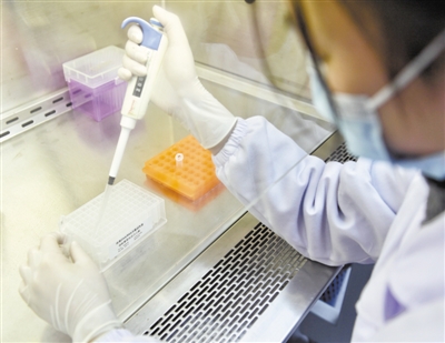 近日，成都新百基生物科技有限公司技术人员在对病毒核酸提取试剂盒进行质量检测。新华社记者 刘坤摄