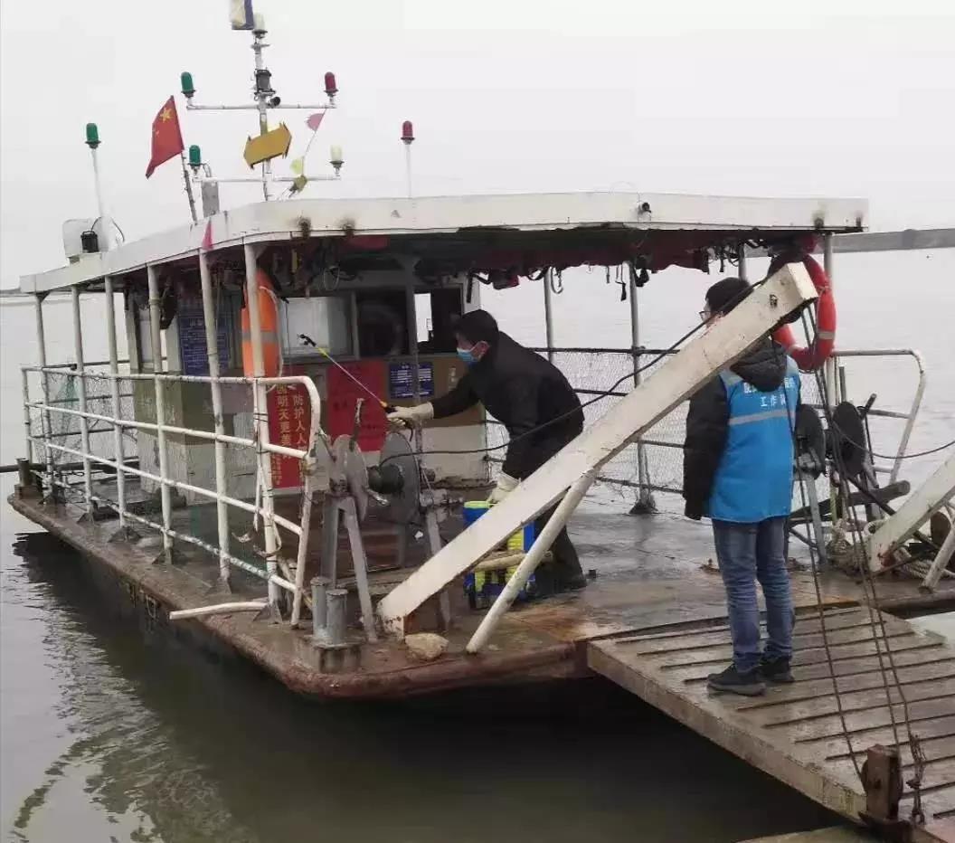 沙岗镇七星村委工作队员协助村干部对渡船进行消毒