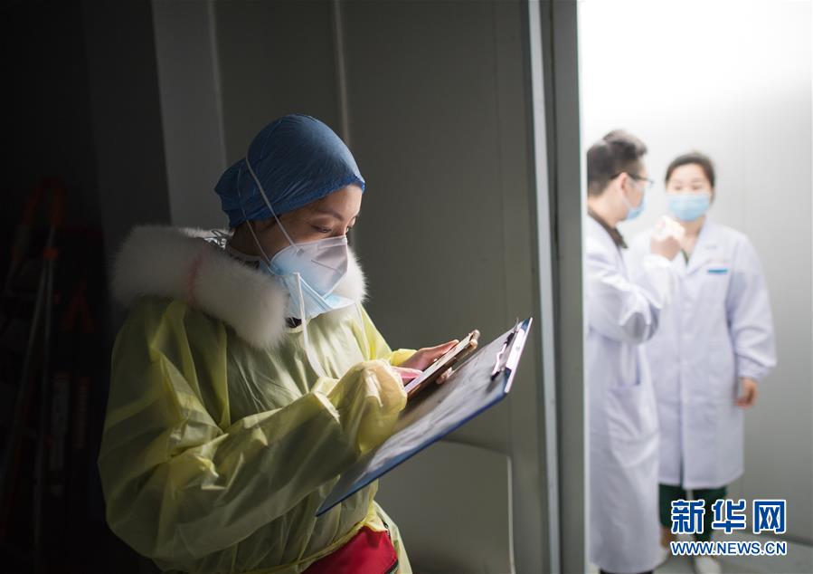 武汉市第一医院党员护士长孙纯（左）在武汉雷神山医院翻看患者医嘱情况（2月8日摄）。  新华社记者 肖艺九 摄