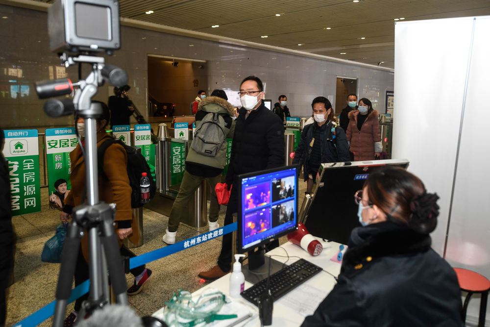 在杭州东站，从贵州乘坐外地复工人员专列抵达杭州的复工人员出站时经过红外测温仪（2月16日摄）。 新华社记者 黄宗治 摄