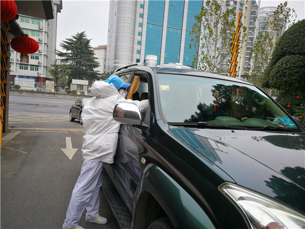 新华社门诊部护士关悦协助司机进行采访车消毒