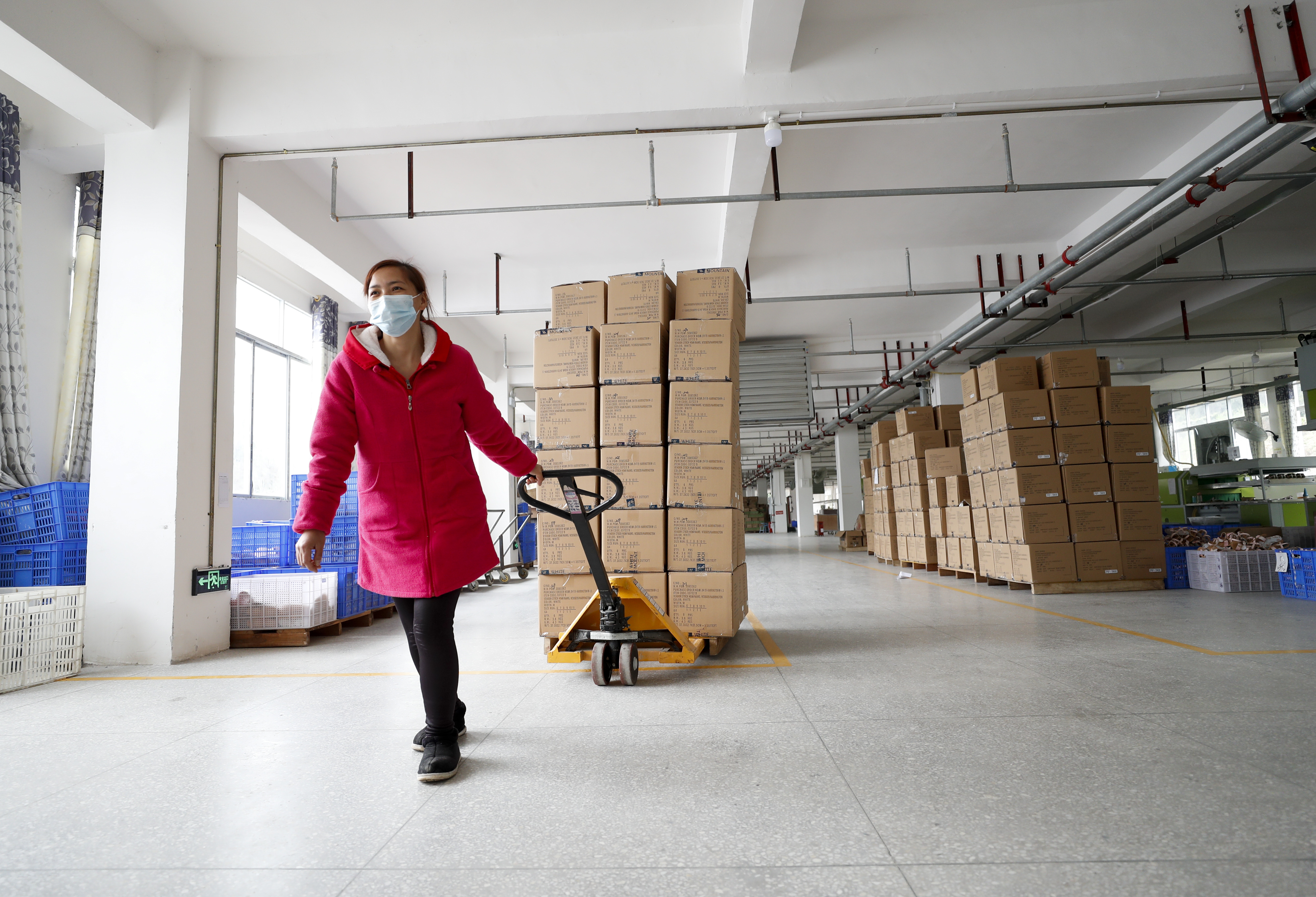 　　在重庆市巫溪县鸿驰鞋业有限公司扶贫车间，工作人员将准备出口的成品鞋运往楼下装车（2020年2月22日摄）。
