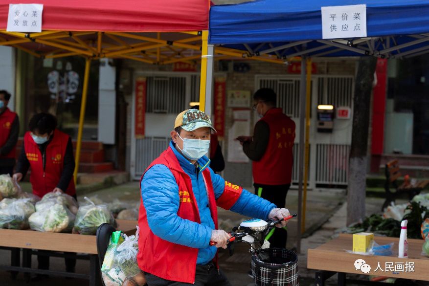 在社区生活物资集中配送点，社区志愿者把爱心菜和生活物资为居民送上门。