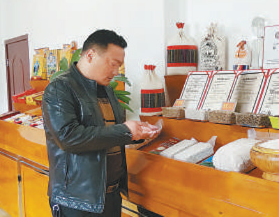 泽仁顿珠在检查公司展示的特色青稞产品。