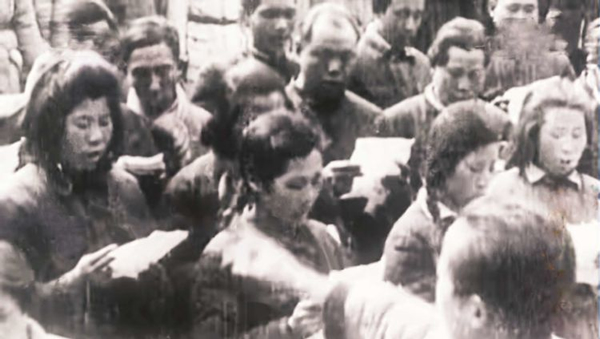 延安电影团当年在延安拍摄的电影素材中出现的张建珍(右一）与战友们排练《黄河大合唱》的镜头。