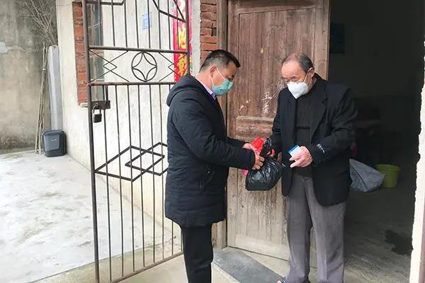 全国人大代表、武汉市新洲区潘塘街陈玉村党支部书记张文喜为村民送药品。