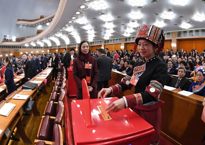 △2018年3月11日，在十三届全国人大一次会议第三次全体会议上，代表们在投票表决《中华人民共和国宪法修正案（草案）》。