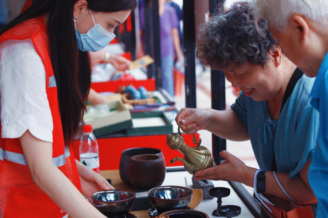 非遗集市上，茶亭社区居民在体验点茶。