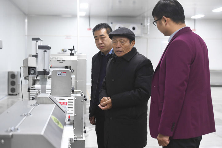 2月21日,在位于河南省濮阳市庆祖镇西辛庄村的食品工业园,李连成(中)查看即将投产的馒头生产线。新华社记者 张浩然 摄