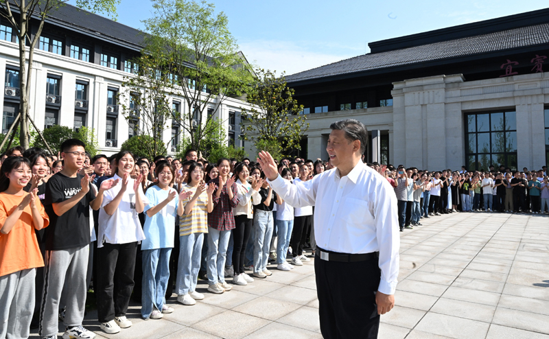 2022年6月8日，习近平总书记在宜宾学院考察时，向师生们挥手致意。