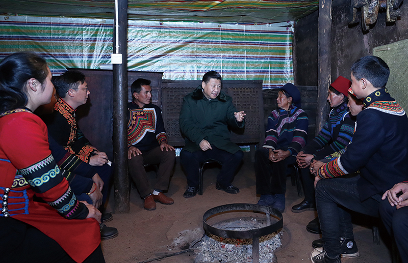 习近平在节列俄阿木家中同村民代表、驻村扶贫工作队员围坐火塘边,共谋精准脱贫之策。