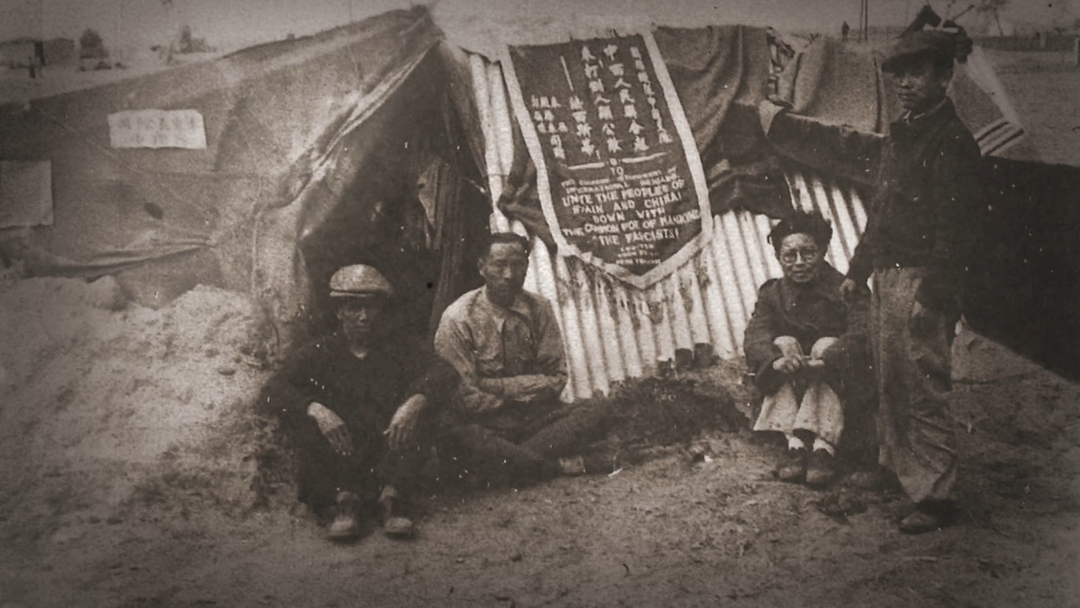 謝唯進和戰友在集中營與錦旗的合影