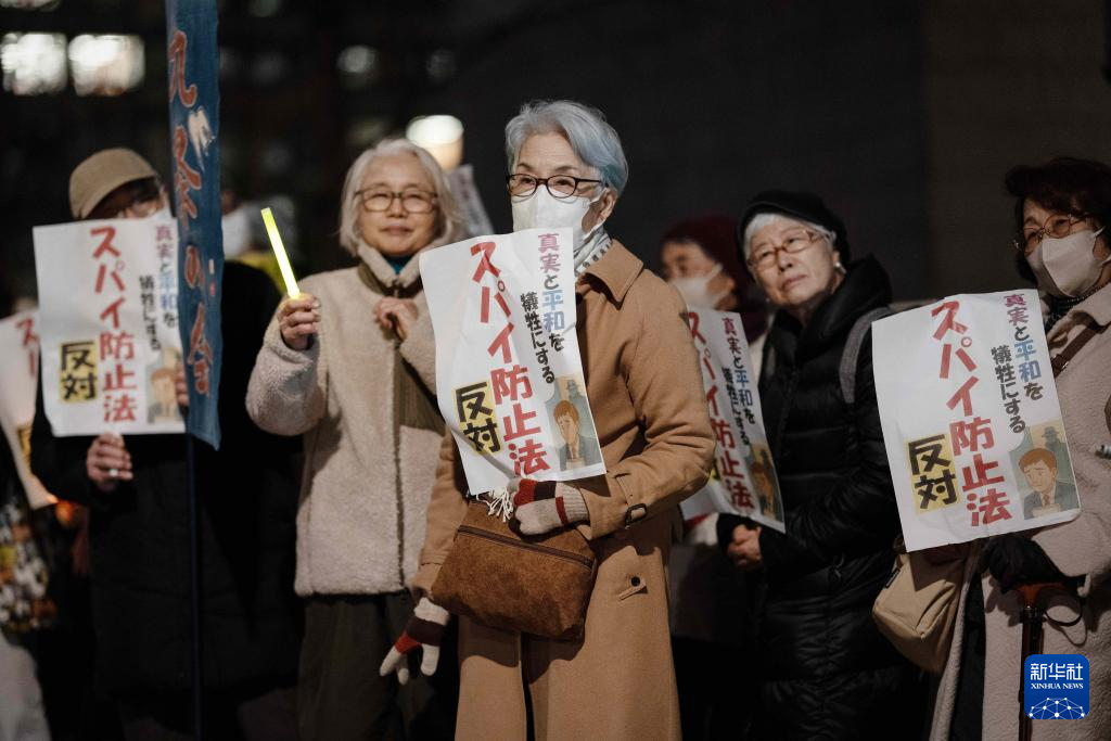 2月24日,在日本东京的众议院第二议员会馆前,民众手持标语参加抗议活动。新华社记者 贾浩成 摄