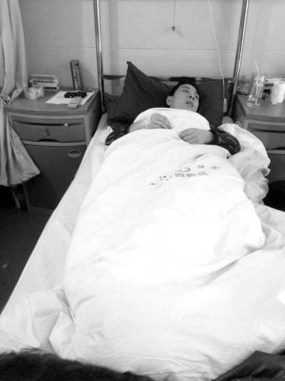 当事人徐世涛躺在垫江县中医院的病床上,由于腰椎和肋骨骨折,他难以