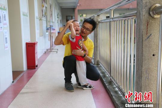 杨建琪陪正在安抚一名幼儿。 林馨 摄 中新网柳州9月6日电 题:广西“95后”男幼师:刚柔并济的“孩子王” 作者林馨 杨建琪耐心安抚一名哭闹的孩子。 林馨 摄 “男幼师不仅和女老师一样耐心细致,还柔中带刚,给孩子树立阳光、威严的一面。”广西柳州市直机关第二幼儿园“95后”男幼师杨建琪6日表示。 8时许,剪着寸头、干净阳光的大男孩杨建琪,正在配合小班老师安抚哭闹不停的孩子。新学期新生入